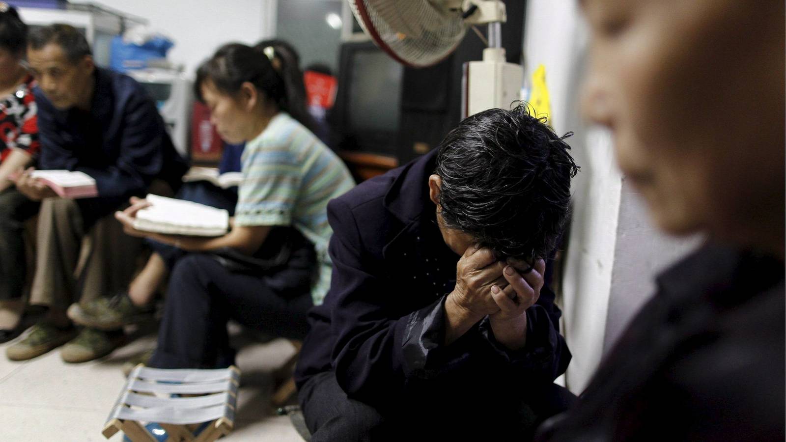 Varias personas leen la Biblia en Lueyang, China. Foto: EFE