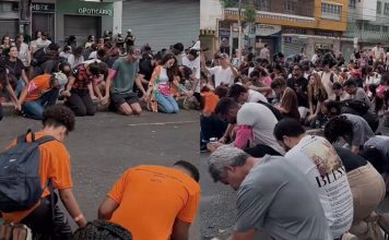 Jóvenes cristianos oran de rodillas en medio del Carnaval de Belo Horizonte